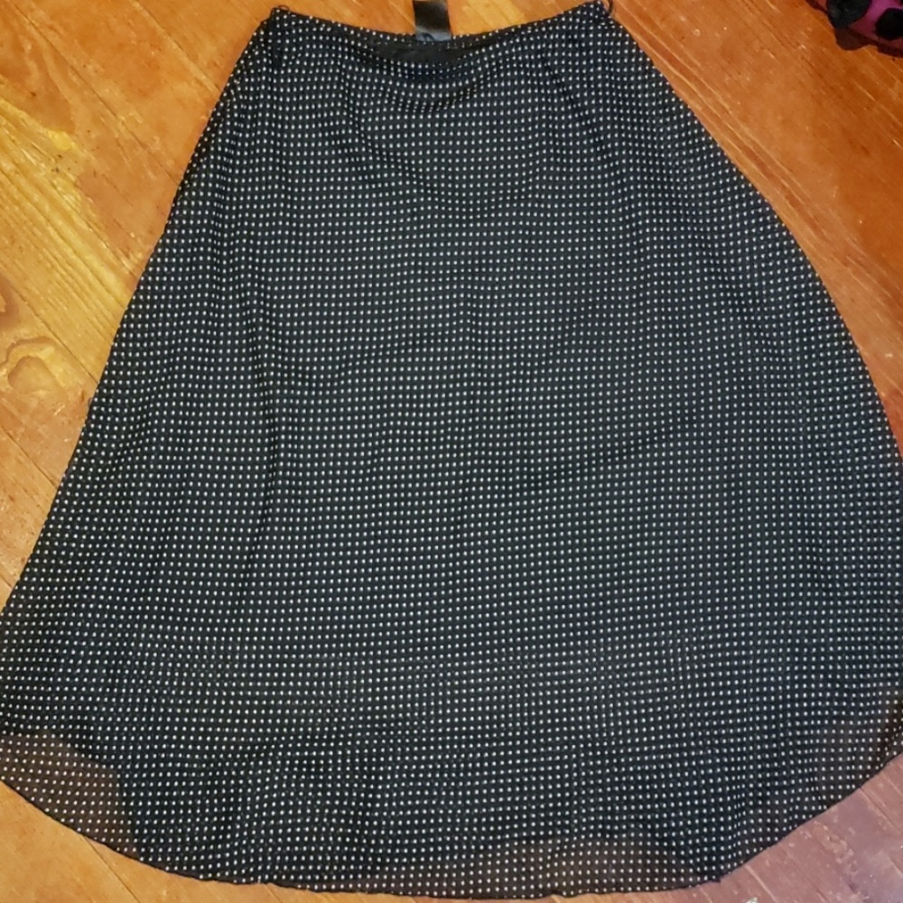A shaped long black and  polka dot skirt.
